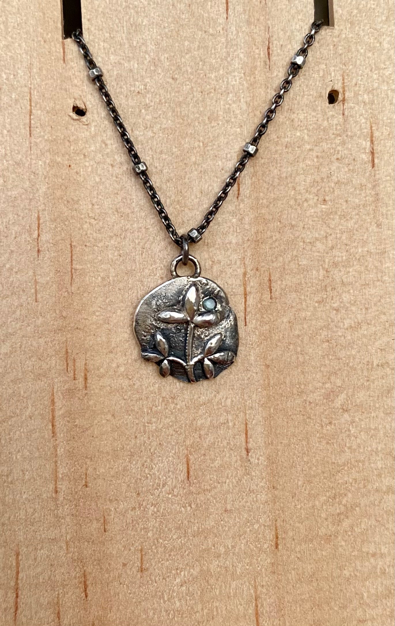 Small leaf pendant with blue sapphire