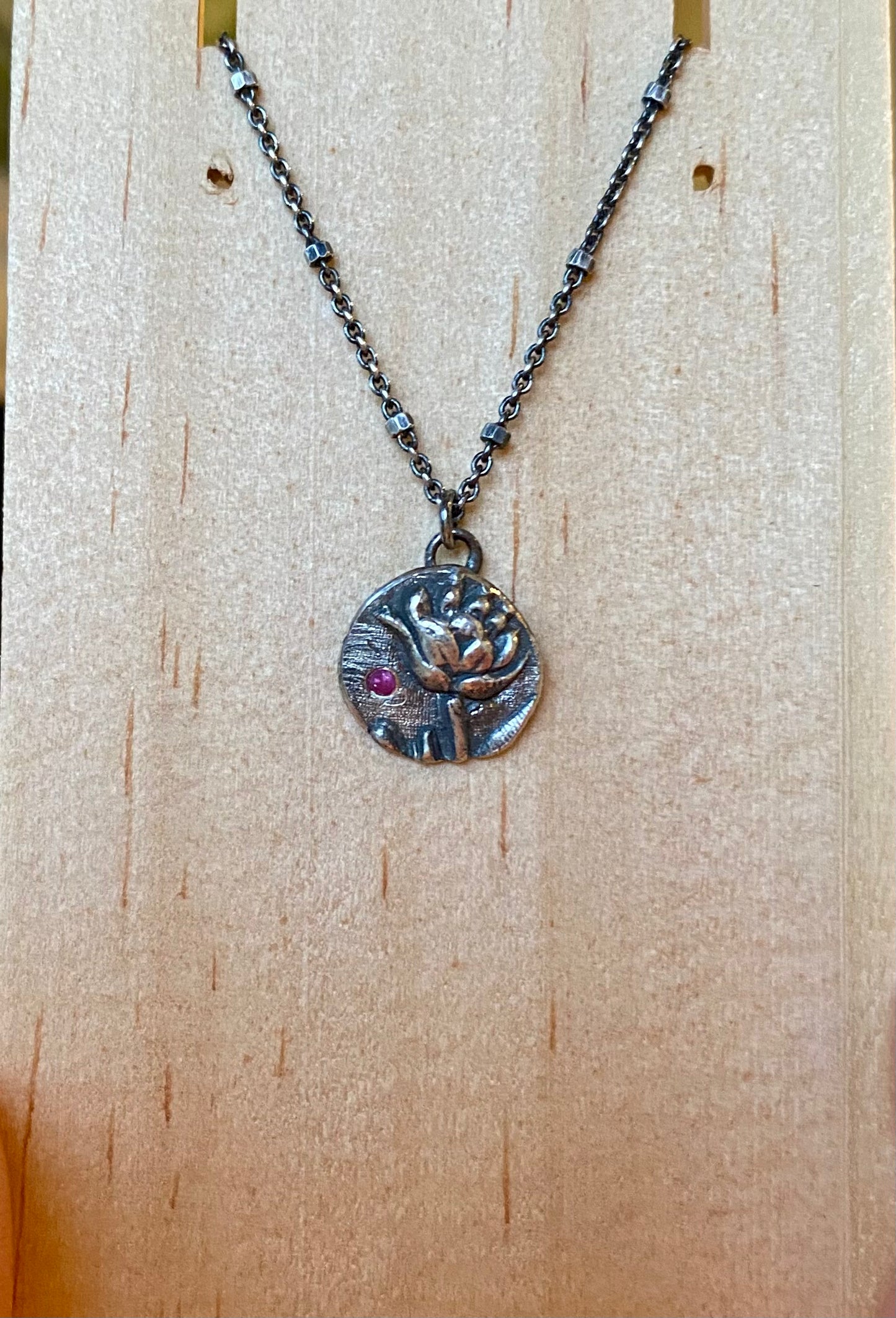 Sterling silver lotus pendant with pink sapphire on 16”-18” chain