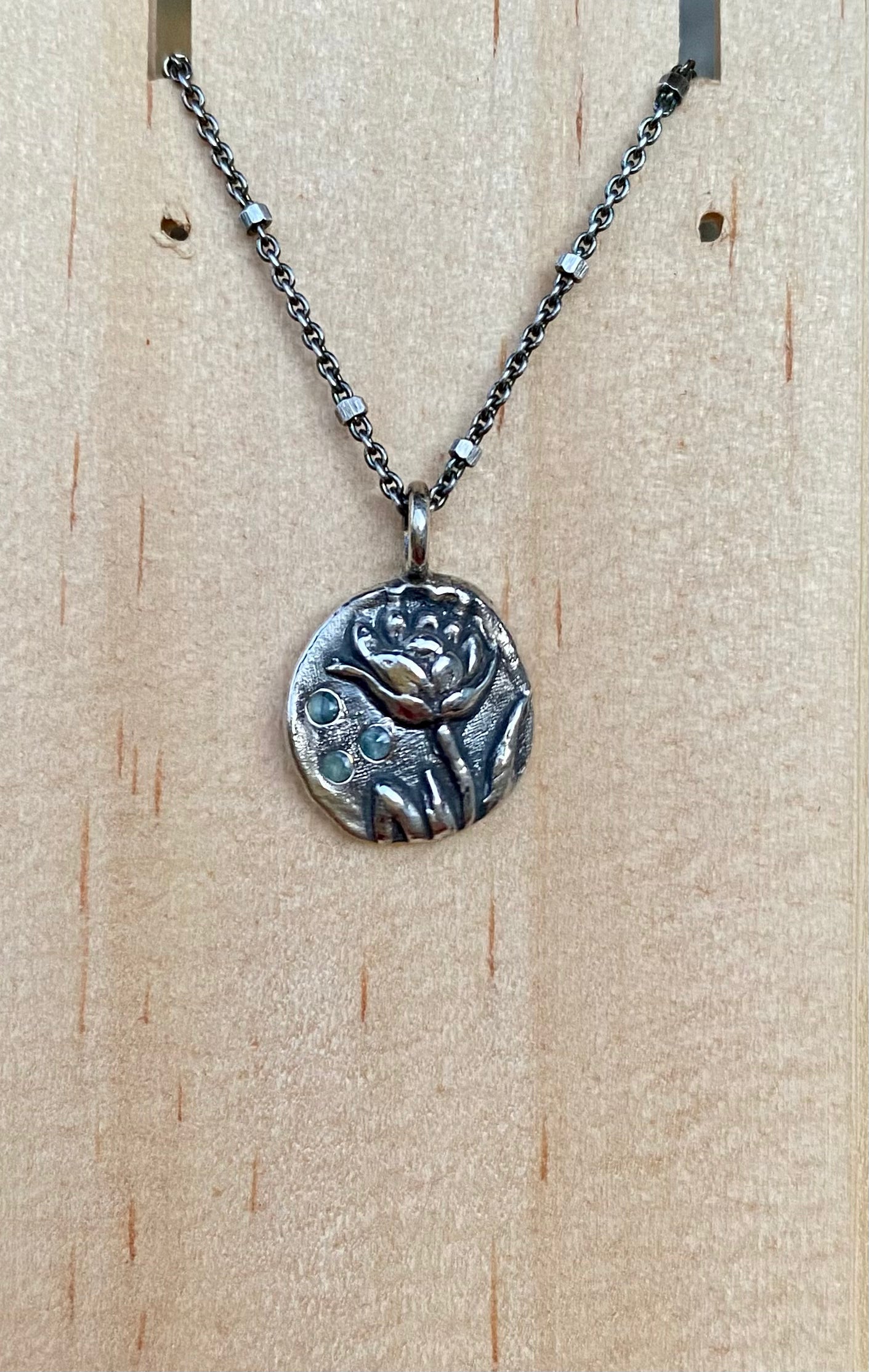Sterling silver lotus pendant with blue sapphires on 16”-18” beaded chain